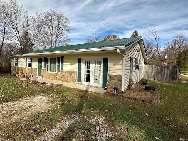 rear view of property featuring a yard and french doors