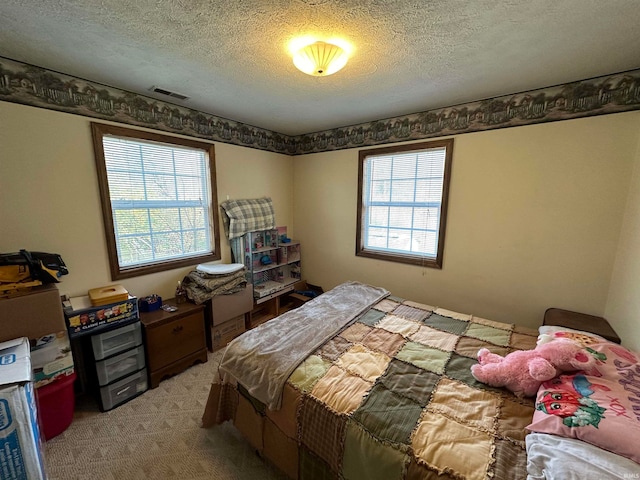 carpeted bedroom with multiple windows and a textured ceiling