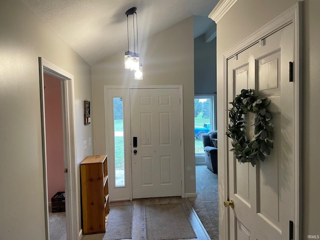 carpeted foyer with lofted ceiling and a textured ceiling