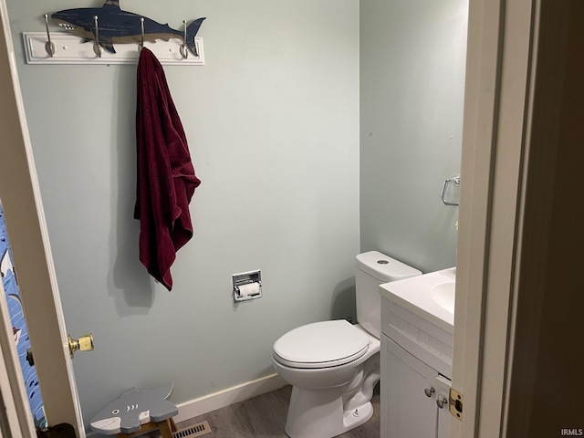 bathroom featuring toilet, vanity, and wood-type flooring