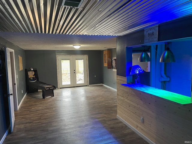 unfurnished room featuring bar area, wood-type flooring, and french doors