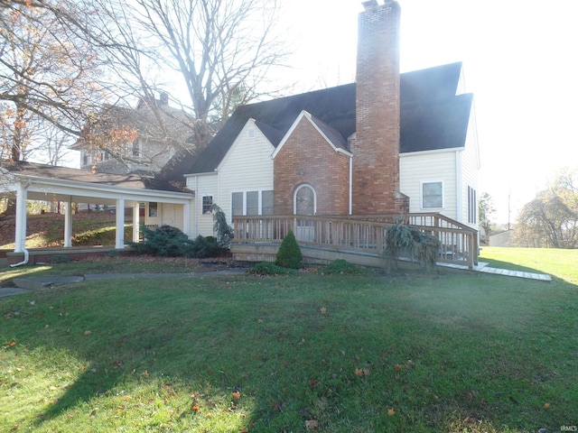 rear view of house featuring a lawn and a wooden deck