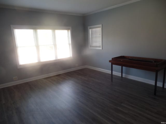 empty room with dark hardwood / wood-style flooring and ornamental molding