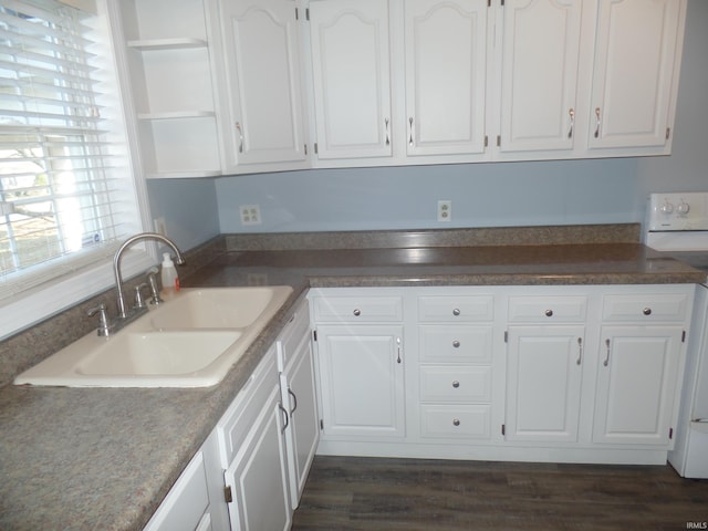 kitchen with dark wood-type flooring, white cabinetry, sink, and white range