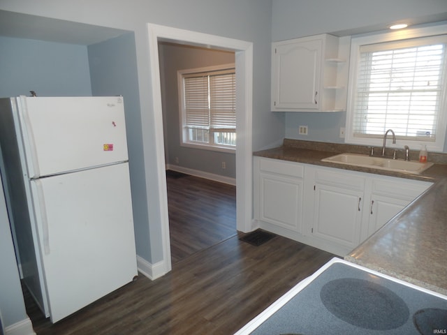 kitchen with dark hardwood / wood-style floors, white cabinetry, sink, and white refrigerator