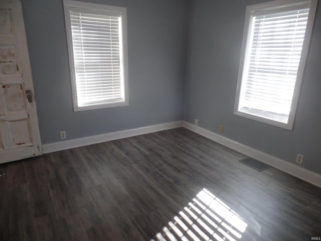 unfurnished room with dark hardwood / wood-style flooring