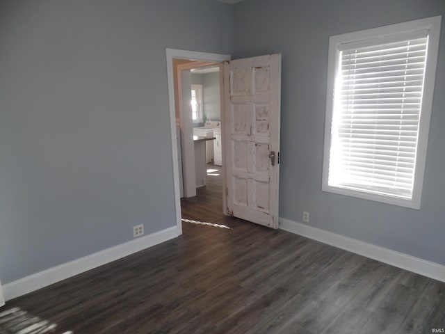 unfurnished room featuring dark hardwood / wood-style floors and washer / dryer