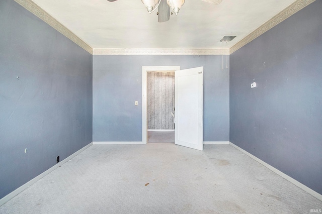 carpeted spare room with ceiling fan and crown molding