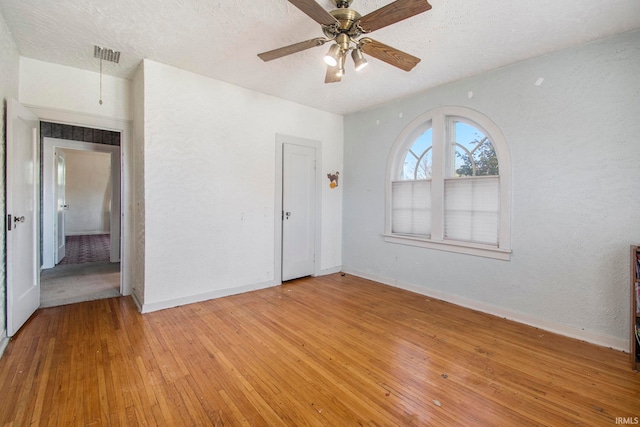 unfurnished room featuring ceiling fan, a textured ceiling, and light wood-type flooring