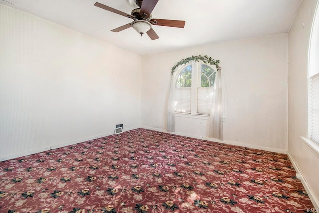 carpeted spare room with ceiling fan