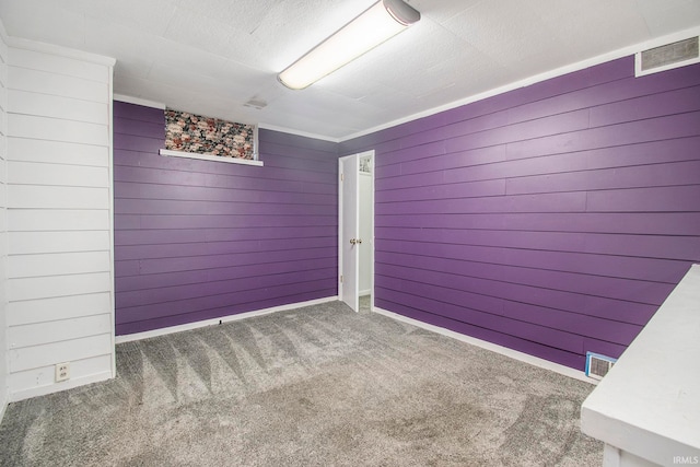 spare room with wood walls and dark colored carpet