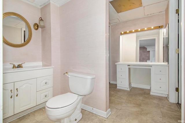 bathroom with toilet, vanity, and crown molding