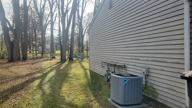 view of side of property with central air condition unit and a yard