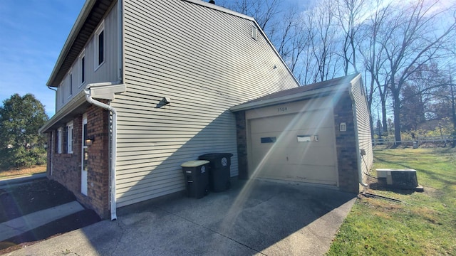 view of side of property featuring a garage, cooling unit, and a lawn