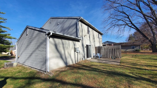 view of property exterior featuring central AC unit and a yard