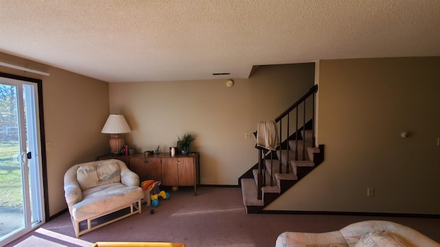 living area featuring carpet and a textured ceiling