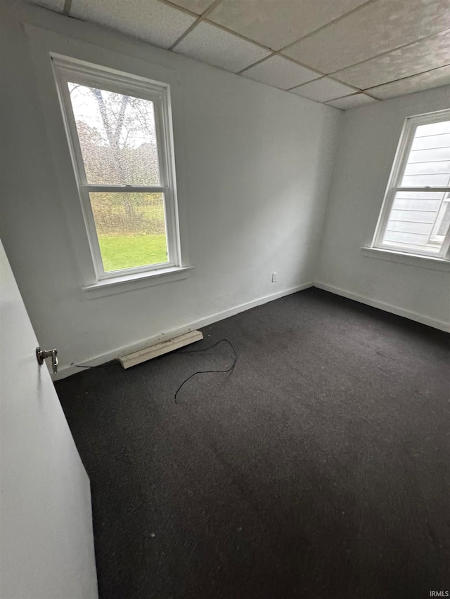 carpeted spare room featuring a paneled ceiling