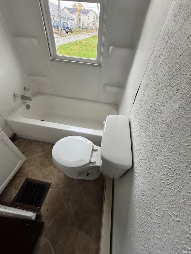 bathroom featuring shower / tub combination and toilet