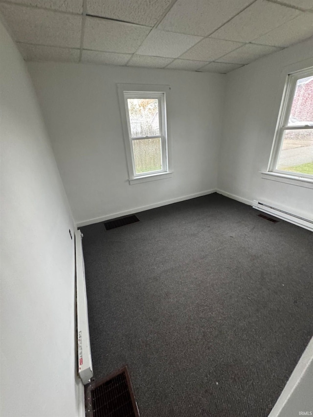 unfurnished room with a drop ceiling, carpet flooring, and a baseboard radiator