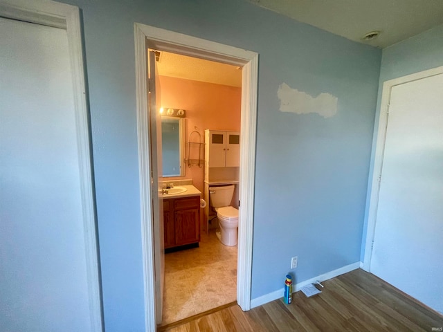 bathroom featuring toilet, vanity, and wood-type flooring