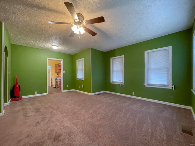 spare room featuring carpet, a textured ceiling, and ceiling fan