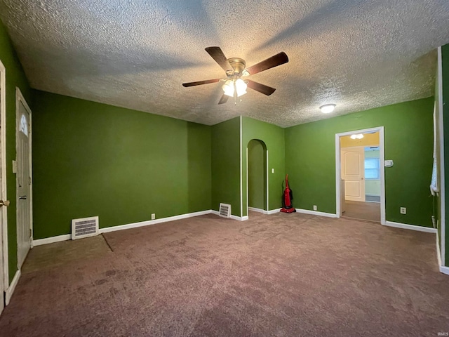 carpeted empty room featuring ceiling fan and a textured ceiling