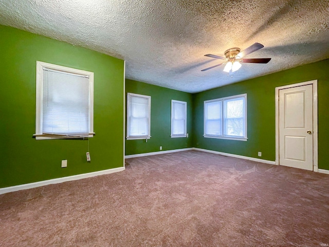 carpeted spare room featuring a textured ceiling and ceiling fan