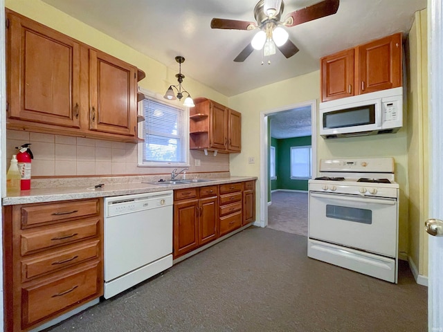 kitchen featuring white appliances, sink, ceiling fan, decorative backsplash, and decorative light fixtures