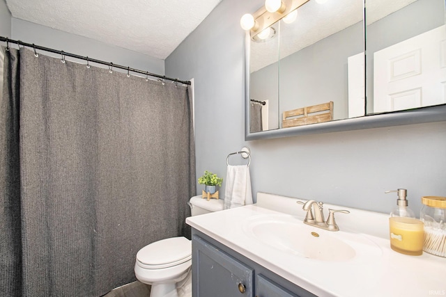 bathroom featuring vanity, a textured ceiling, and toilet