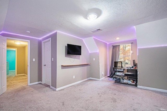 interior space with a textured ceiling and carpet floors