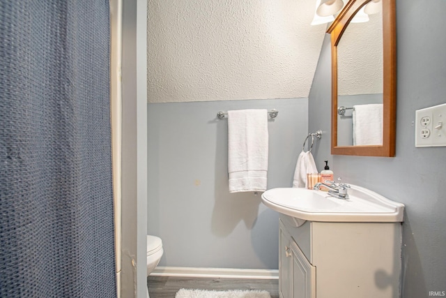 bathroom with walk in shower, hardwood / wood-style floors, vanity, and toilet