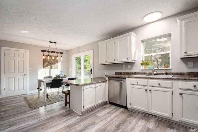 kitchen with light wood-type flooring, sink, white cabinets, dishwasher, and kitchen peninsula