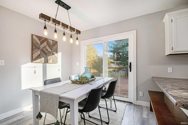 dining room featuring a textured ceiling and light hardwood / wood-style flooring