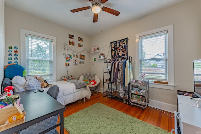 bedroom with ceiling fan, hardwood / wood-style floors, and multiple windows