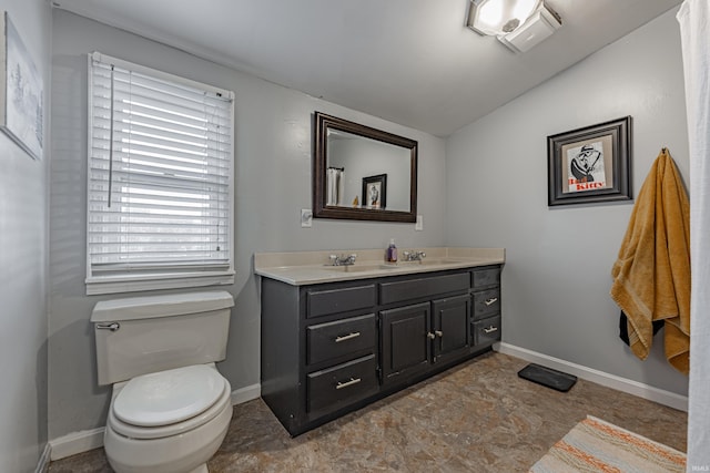 bathroom featuring vanity, lofted ceiling, and toilet