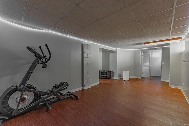 workout area featuring hardwood / wood-style flooring and a paneled ceiling