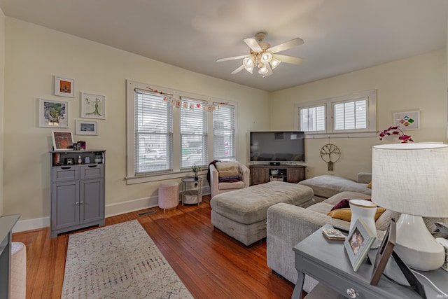 living room with ceiling fan and dark hardwood / wood-style flooring