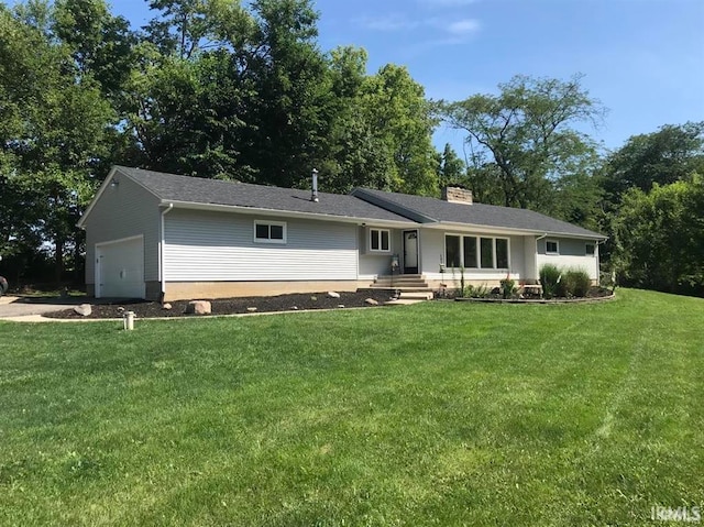 rear view of property with a lawn and a garage