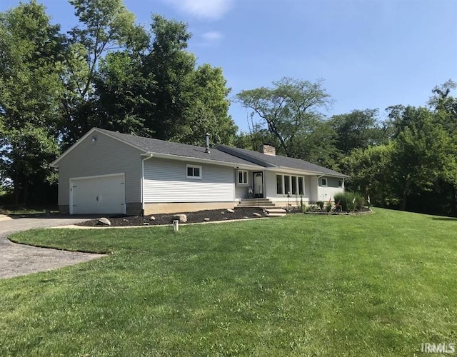 view of front of home with a garage and a front lawn