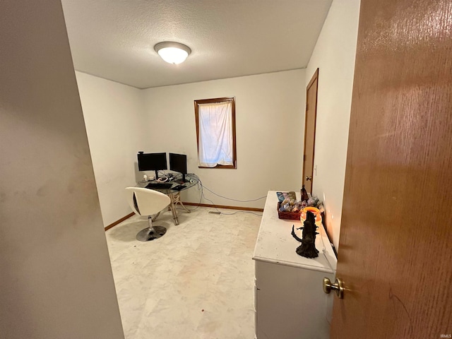 carpeted home office with a textured ceiling