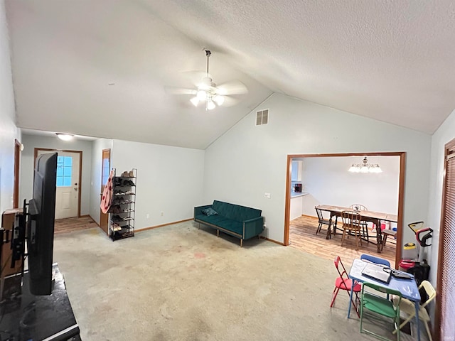 sitting room with a textured ceiling, carpet floors, ceiling fan, and vaulted ceiling