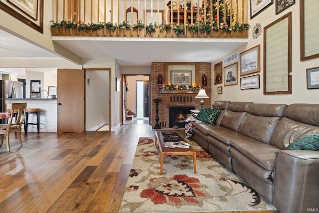 living room featuring hardwood / wood-style floors and a brick fireplace