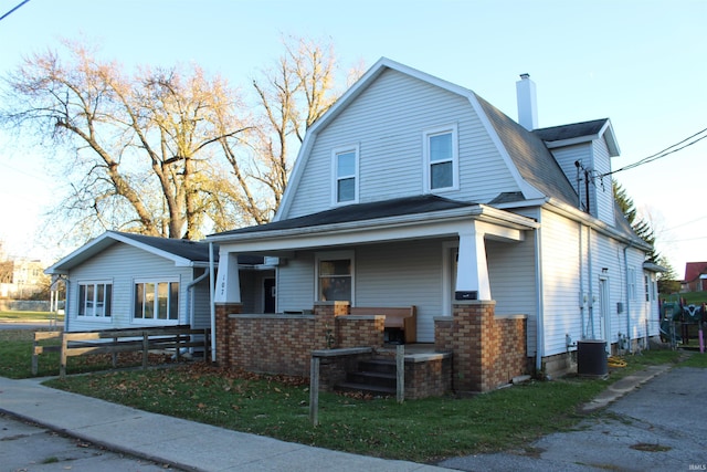 view of front facade with cooling unit and a porch