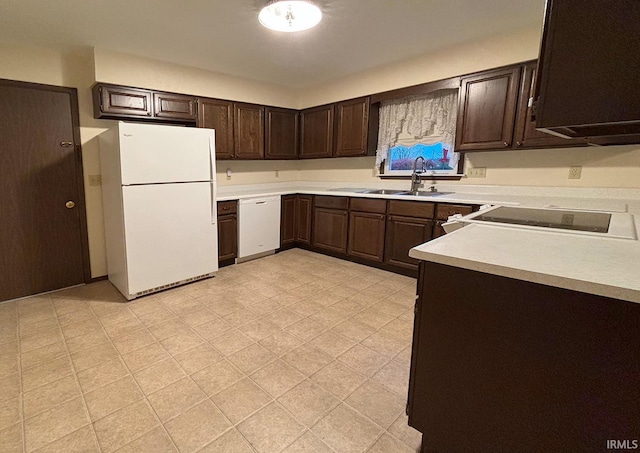 kitchen with dark brown cabinetry, sink, and white appliances