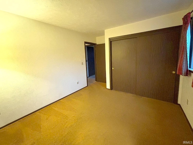 unfurnished bedroom with a closet, a textured ceiling, and carpet floors