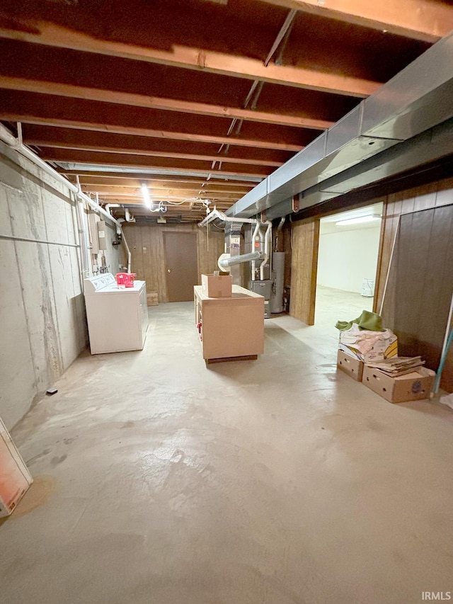 basement with heating unit, gas water heater, and washer and dryer