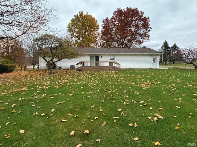 rear view of property with a wooden deck and a yard