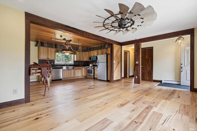 kitchen featuring stainless steel appliances, sink, ceiling fan, light hardwood / wood-style flooring, and a baseboard radiator