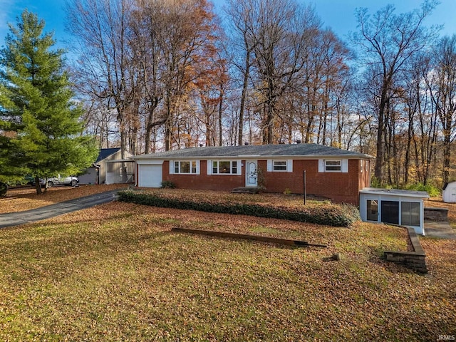 single story home with a garage and a front lawn