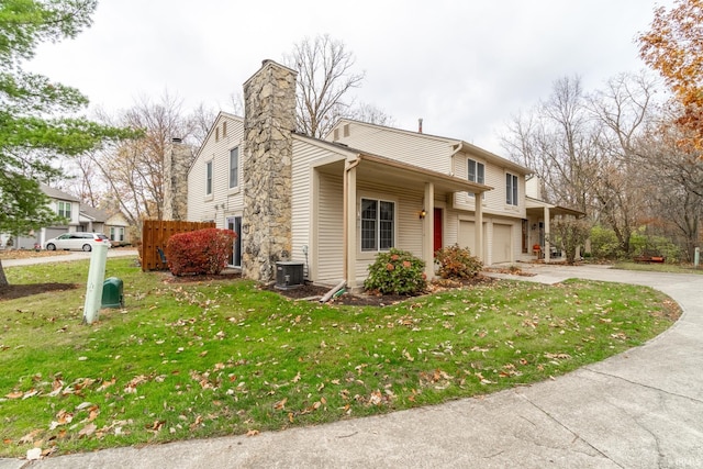 view of side of property featuring a lawn, a garage, and central AC unit